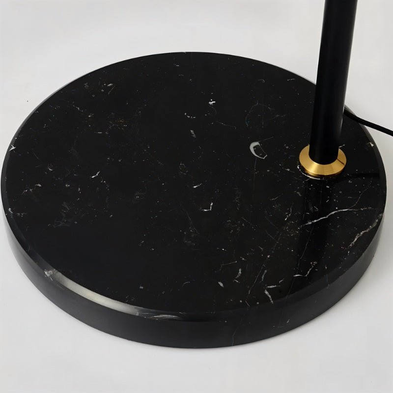 The black marble base and the brass collar where the stem enters the stone