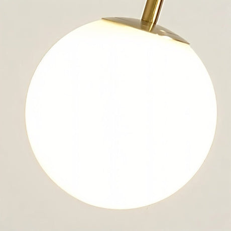 The lit glass globe held by its gold collar at the end of the hooked stem