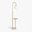A gold stem with a hooked top and a glass globe above a round wooden tray table