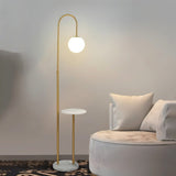 The lamp with a stone tray beside a round chair and cushions in a pale room