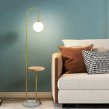 The lit globe beside a beige sofa with cushions against a green wall