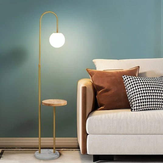 The lit globe beside a beige sofa with cushions against a green wall