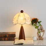 Floral table lamp lit beside sunflowers and a stack of old books