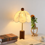 Parasol shade lamp lit brightly, the scalloped hem in silhouette