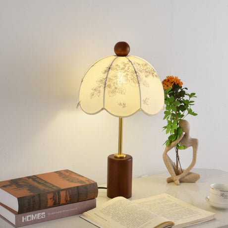 Parasol shade lamp lit on a desk beside an open book and a cup