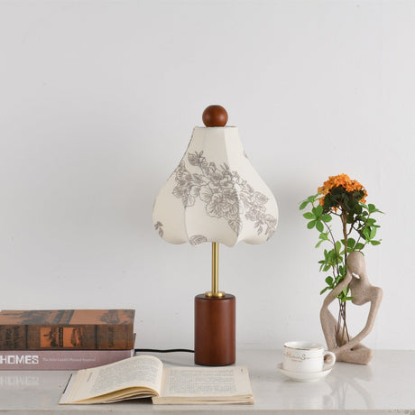 Taller bell shaped shade lit warm beside a stack of books