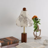 Taller bell shaped printed shade unlit on the same walnut base