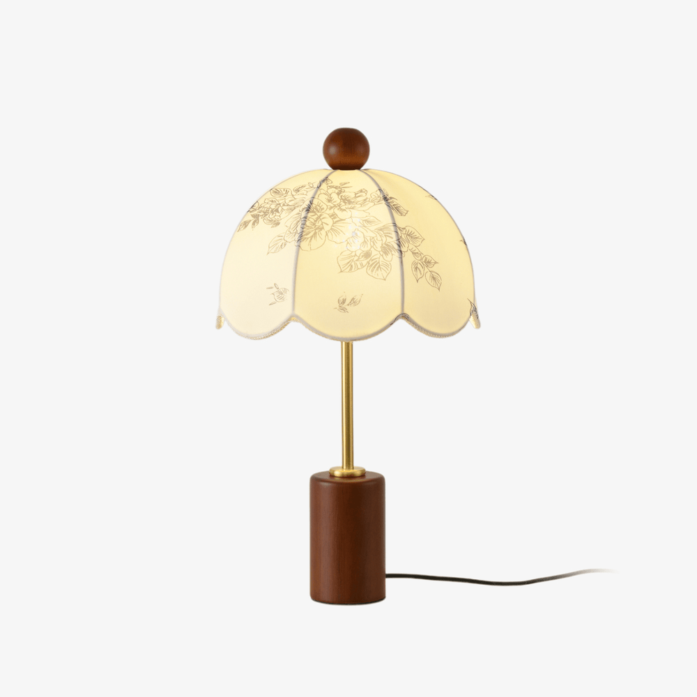 Floral table lamp with a scalloped parasol shade on a walnut cylinder
