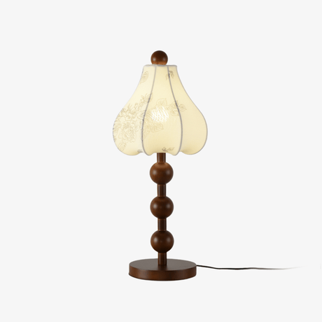 Floral table lamp with a petal shade on a stack of wood spheres, unlit