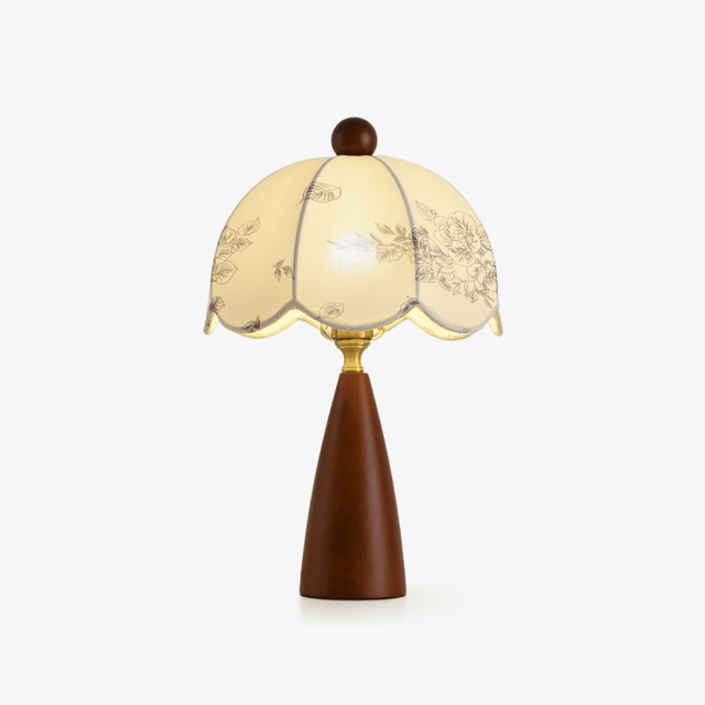 Floral table lamp with a scalloped printed shade on a walnut cone base