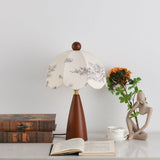 Floral table lamp unlit beside a pale figurine and sunflowers