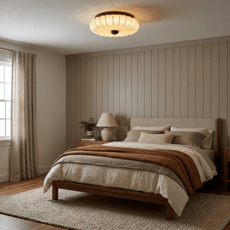 Pleated petal ceiling light in a bedroom with paneled walls and a lamp