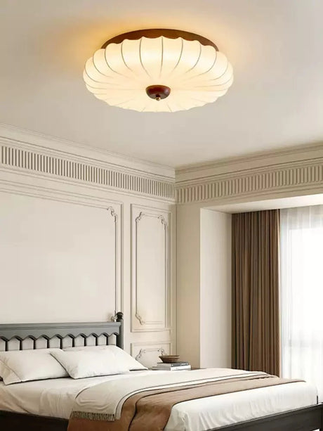 Pleated petal ceiling light in a bedroom with molded wall panels