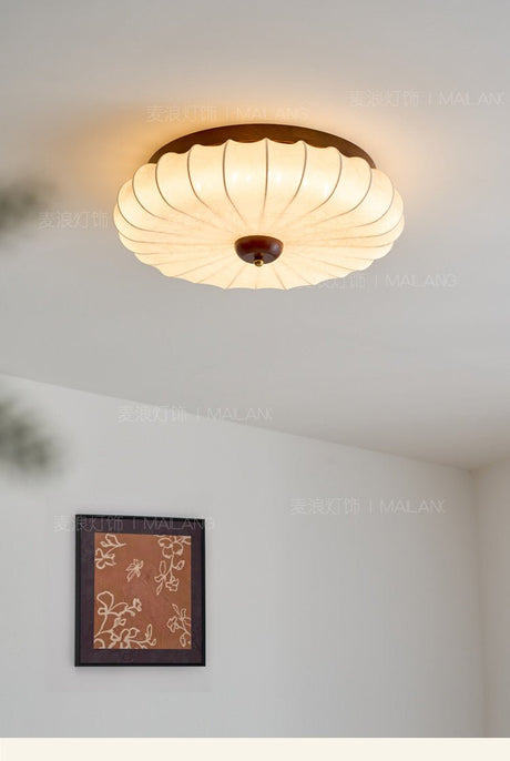 Pleated petal ceiling light seen close against a plain ceiling