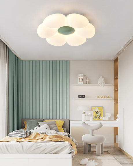 Flower ceiling light with a green center above a bed and a desk