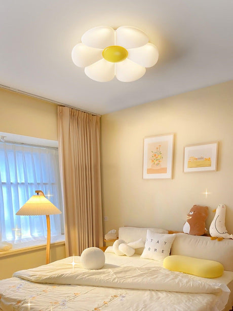 Flower ceiling light with a yellow center above a bed with yellow pillows