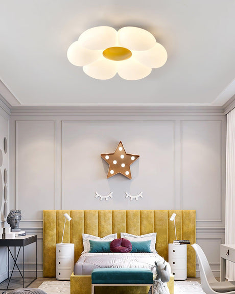 Flower ceiling light with a yellow center above a yellow upholstered bed