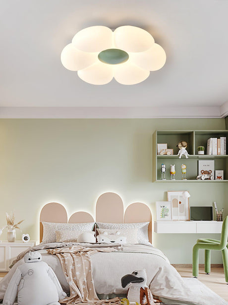 Flower ceiling light with a green center above a bed with a scalloped headboard