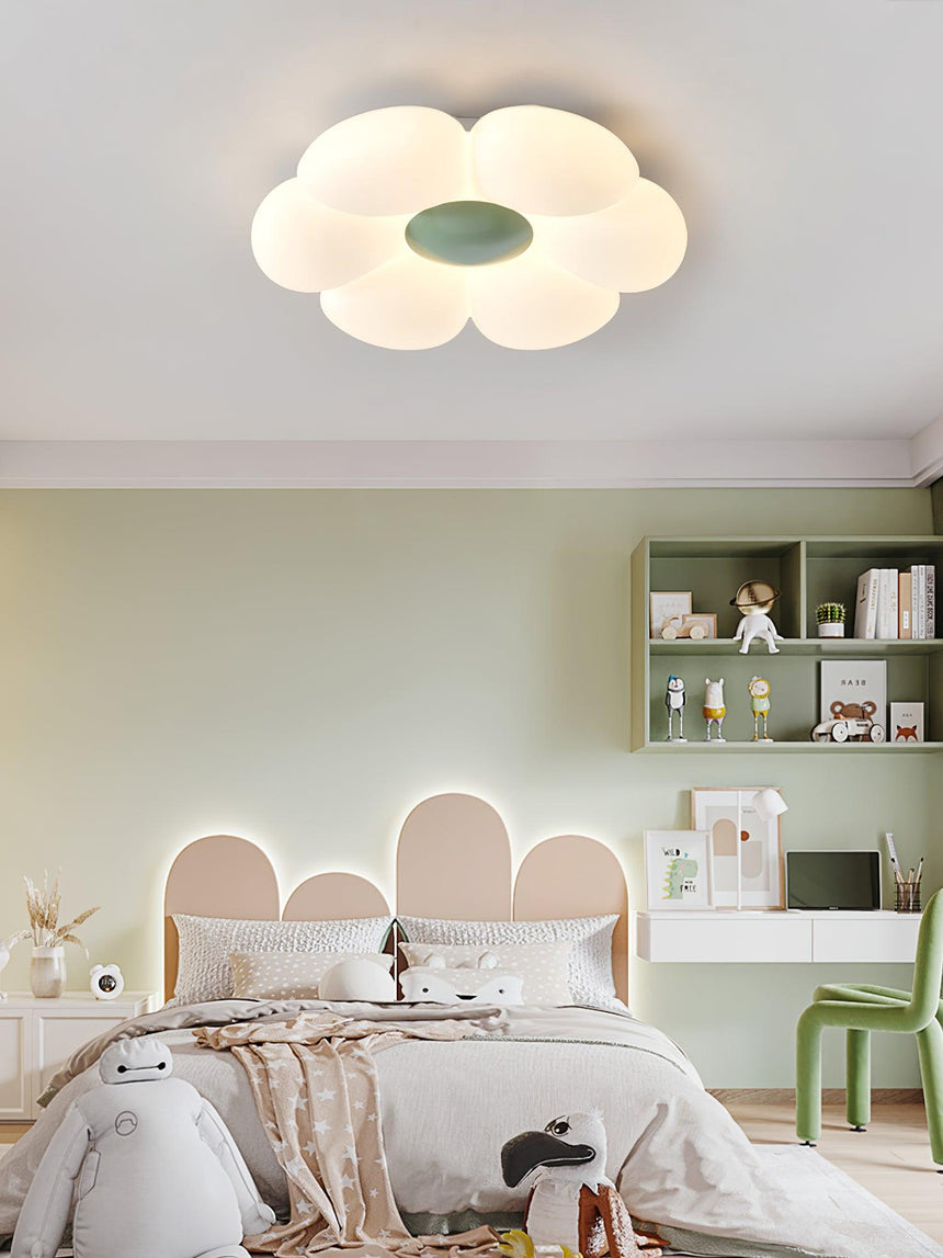 Flower ceiling light with a green center above a bed with a scalloped headboard