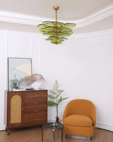 The green petal shade lit in a room with a wooden chest and an orange chair