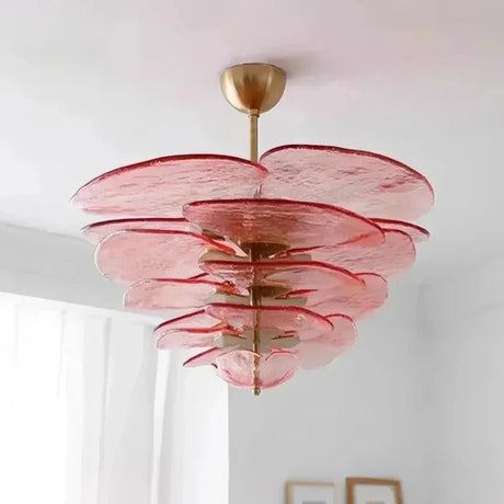 The pink glass petal shade lit under a plain white ceiling