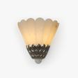 Fan shaped stone shade above a crown of silver metal petals on a wall