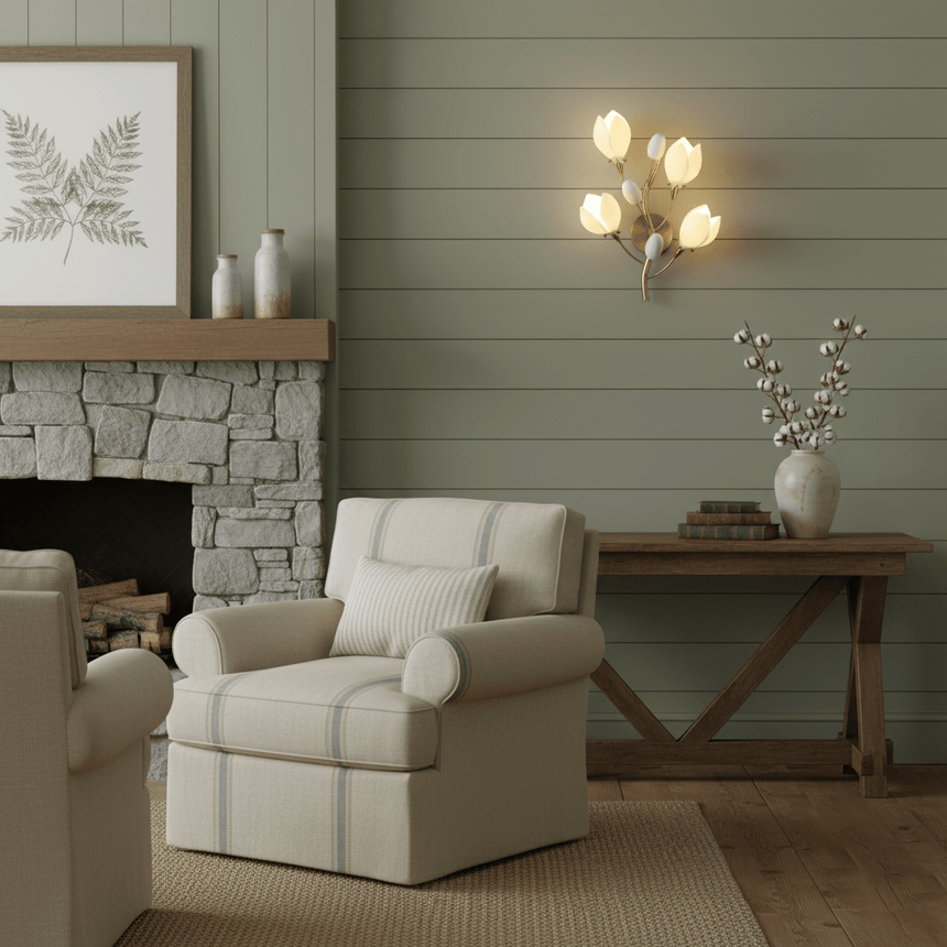 The magnolia light above a console table behind a cream armchair near a stone fireplace