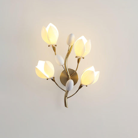 The porcelain blooms lit warm on a beige wall, the gold branches between them