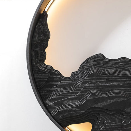 Black carved disc lit along its upper edge, seen from a low angle