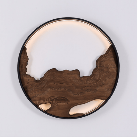 Round wall light with carved wood contours and a lit band above them