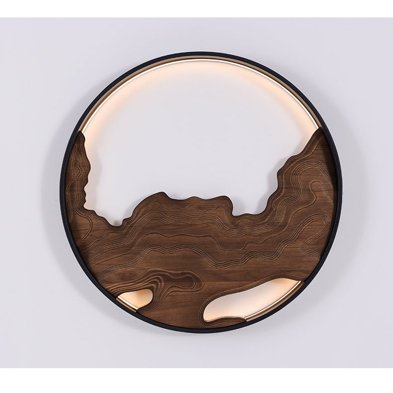Carved walnut layers inside a black ring, the upper arc glowing warm