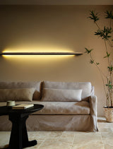Rod lit horizontally above a slipcovered sofa in a bright room
