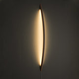 Wood rod lit, a warm halo of light tracing the wall behind it