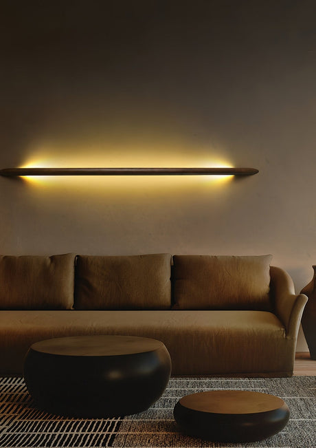 Rod mounted horizontally above a sofa, the wall washed warm behind