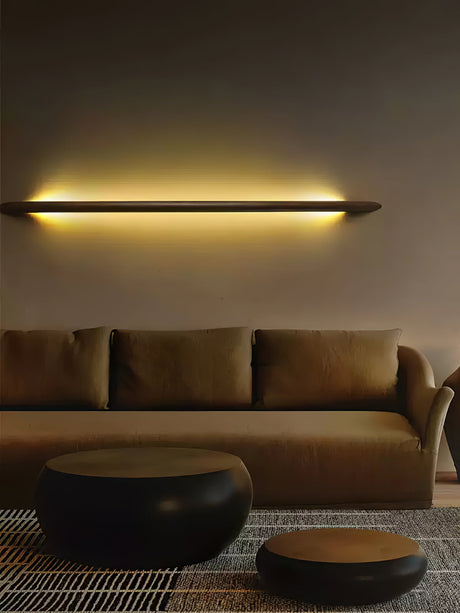 Lit rod above a wide sofa seen from across a plain living room