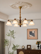 The chandelier seen angled above a chest of drawers and framed art