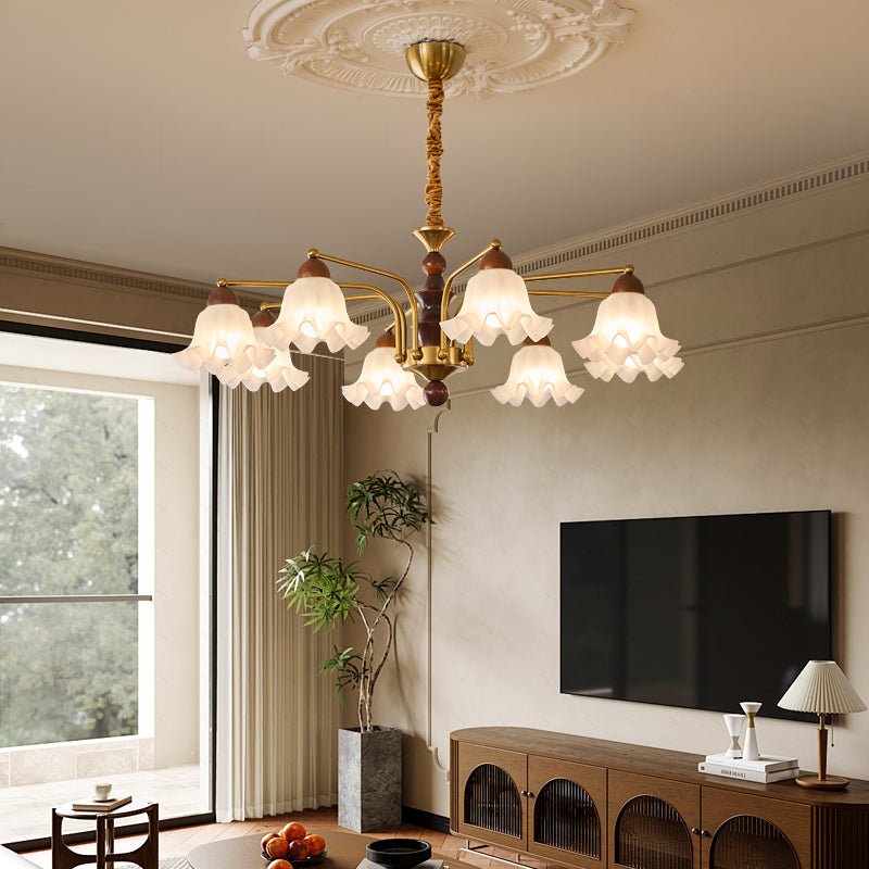 Chandelier lit in a living room above a low table and a wall screen