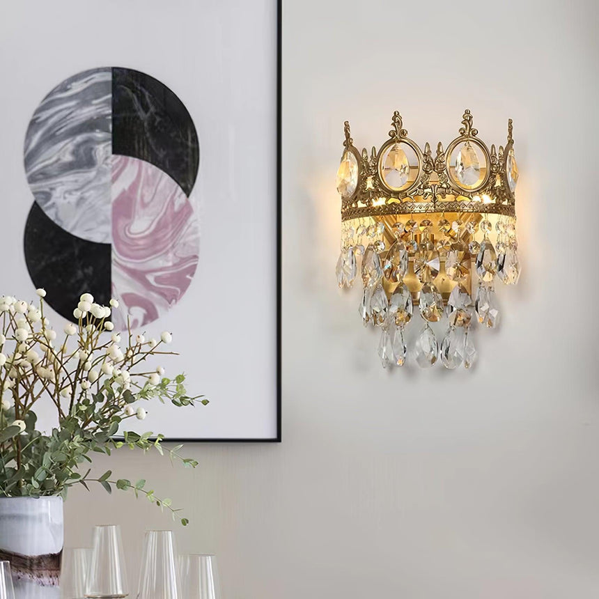 The crown lamp lit beside a framed print above a table with white flowers