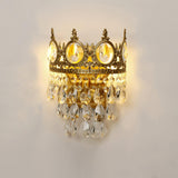 The crown lamp lit warm, the crystal drops glowing below the medallions