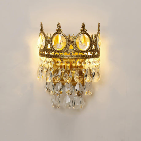 The crown lamp lit warm, the crystal drops glowing below the medallions