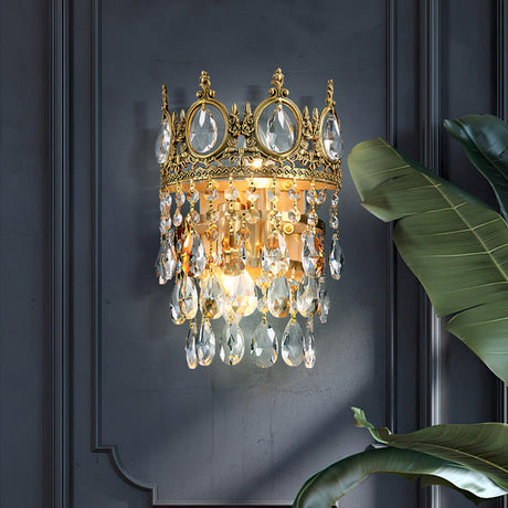 The crown lamp lit on a dark blue paneled wall beside a large leaf plant