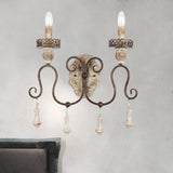 Sconce mounted on a plaster wall above a bed with a gray upholstered frame