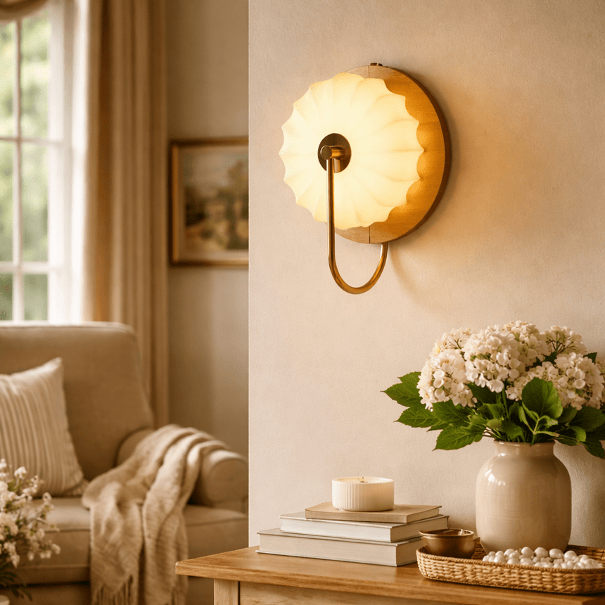 Sconce lit beside an armchair with a throw and a table of hydrangeas