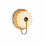 The pale wood version seen from the front with the pleated shade lit