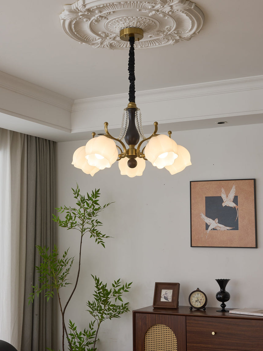 The fitting lit beside a long curtain above a chest and a clock