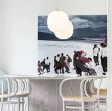 A frosted globe lit above a marble counter beside a framed artwork