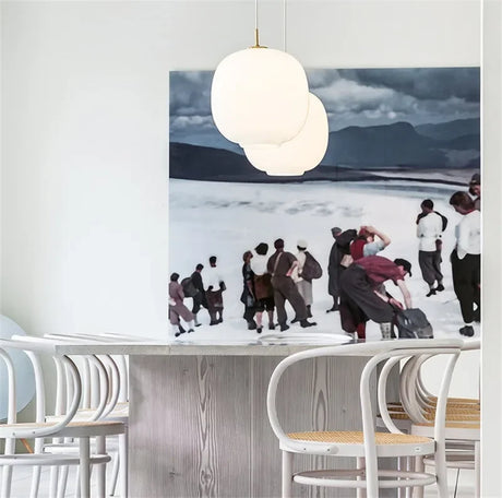 A frosted globe lit above a marble counter beside a framed artwork