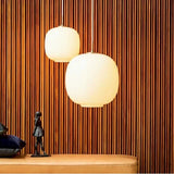 Two frosted globes lit against a slatted wood wall above a console