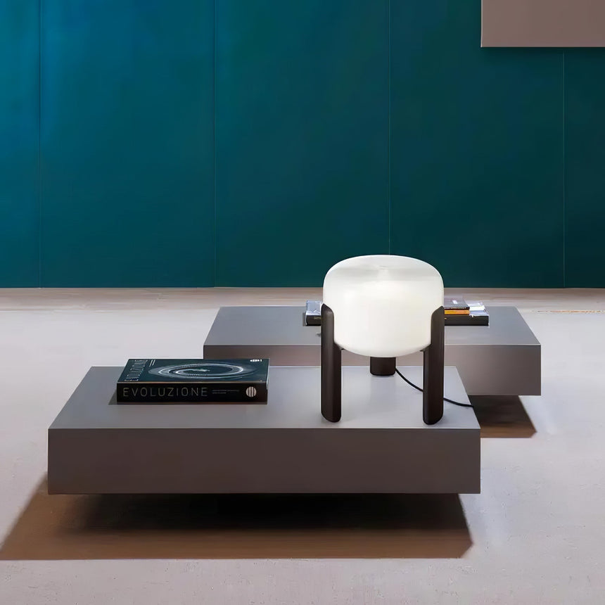 Frosted glass table lamp on a low table seen across a green room