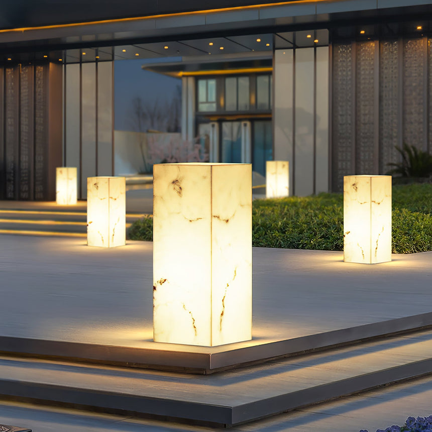 Several lit on stone steps and plinths at the entry to a building